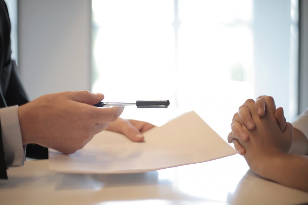 People discussing their loan options holding a pen